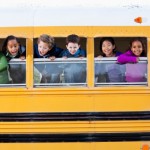 Children looking out school bus window